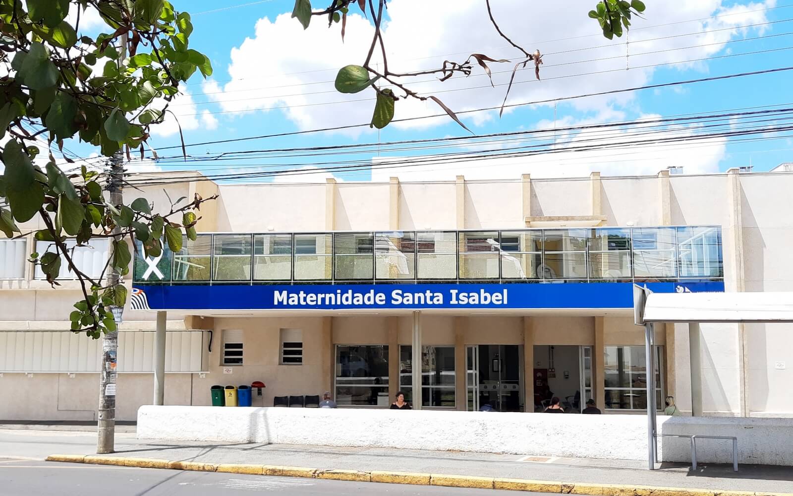 A imagem mostra a fachada da Maternidade Santa Isabel, em Bauru. O prédio tem 1 um andar, portas de vidro e paredes na cor salmão claro.